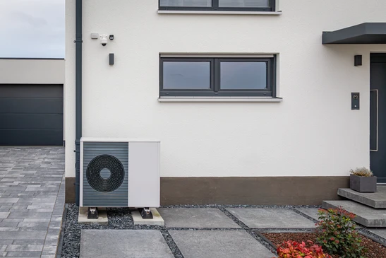 Ext&eacute;rieur r&eacute;sidentiel moderne avec deux unit&eacute;s de pompe &agrave; chaleur air-eau install&eacute;es sur socles b&eacute;ton